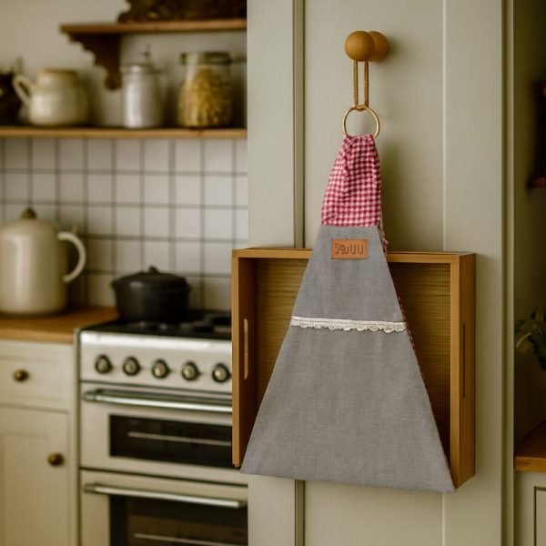 آویز سینی پارچه‌ای با حلقه گینگهامی قرمز و بدنه خاکستری، نصب‌شده روی دیوار آشپزخانه
